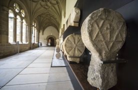 Foto panorámica del claustro bajo con una estela en primer plano a la derecha.