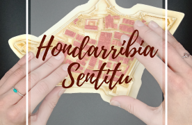 Dos manos tocando la maqueta del casco histórico de Hondarribia.