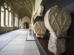 Foto panorámica del claustro bajo con una estela en primer plano a la derecha.