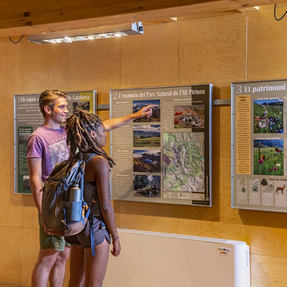 Imatge de un noi i una noia llegint un dels plafons de l'exposició