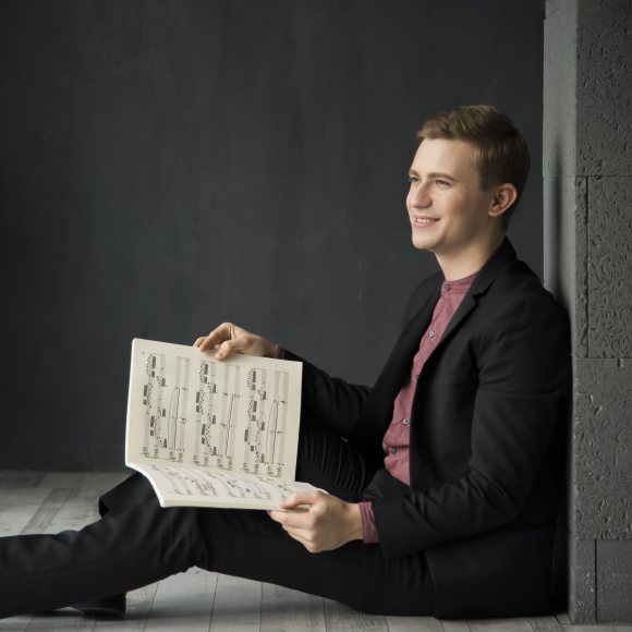 El pianista Dmytro Choni assegut al terra amb una partitura musical a les seves mans